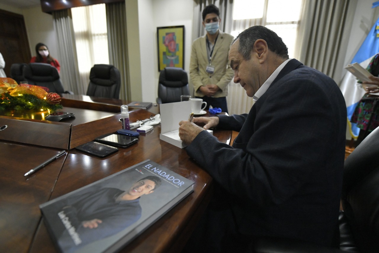 El nadador Luis Carlos Martínez, entregó este jueves un ejemplar de su libro “El Nadador” al presidente Alejandro Giammattei