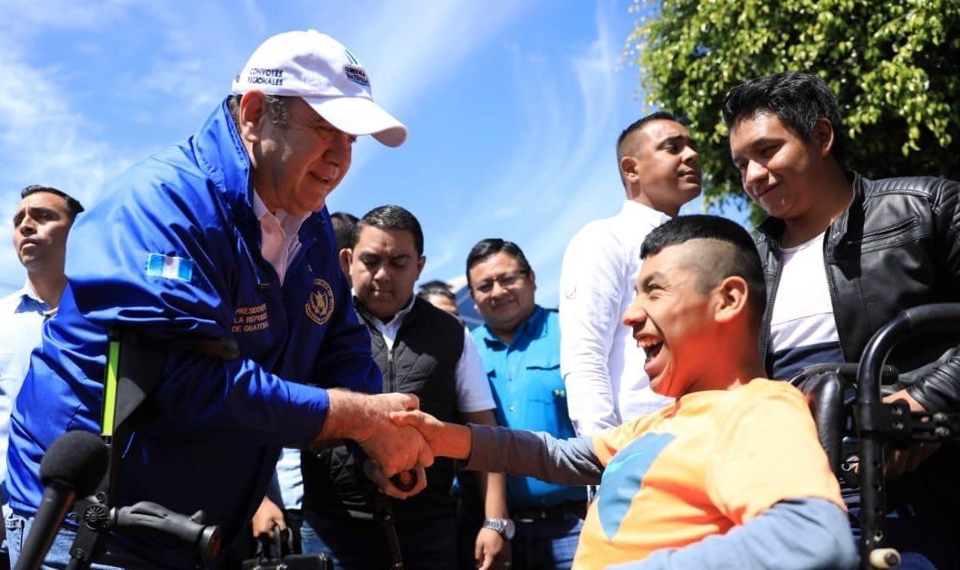 Presidente Alejandro Giammattei, saludando a una persona con discapacidad en una gira de trabajo.