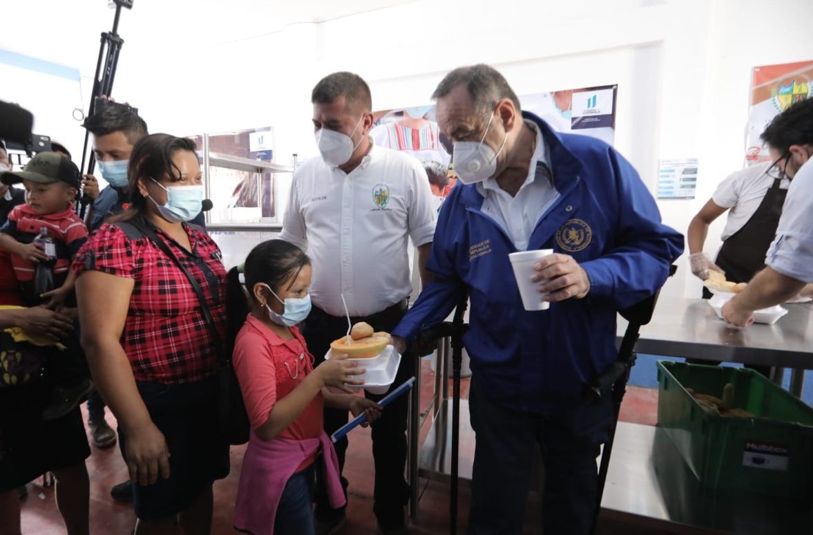 El presidente Alejandro Giammattei entrega alimentos a una mandre junto a su hijo, en el comedor social inaugurado en Camotán, Chiquimula. Foto Gilber García