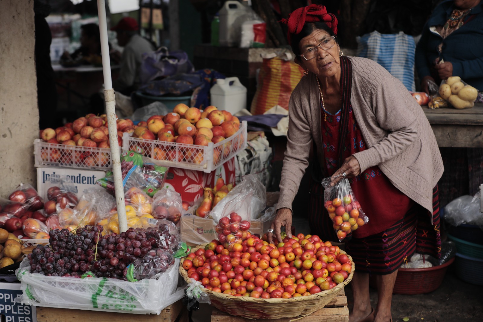 Doña Andrea Sánchez ofrece frescos jocotes, uvas y manzanas en el mercado de Colotenango. /Foto: Noé Pérez