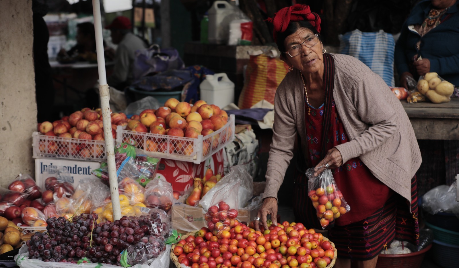 Doña Andrea Sánchez ofrece frescos jocotes, uvas y manzanas en el mercado de Colotenango. /Foto: Noé Pérez