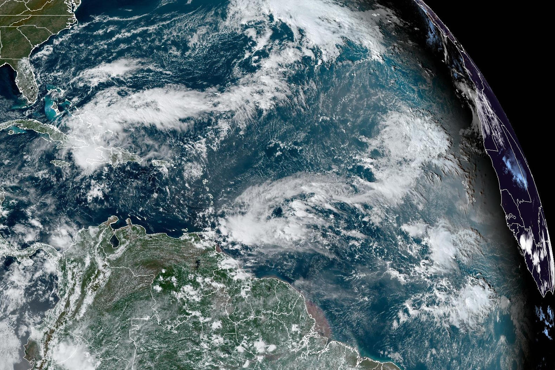 A la izquierda se observa la tormenta tropical Óscar, la cual se debilitó tras impactar a Cuba como huracán. / Foto: EFE.