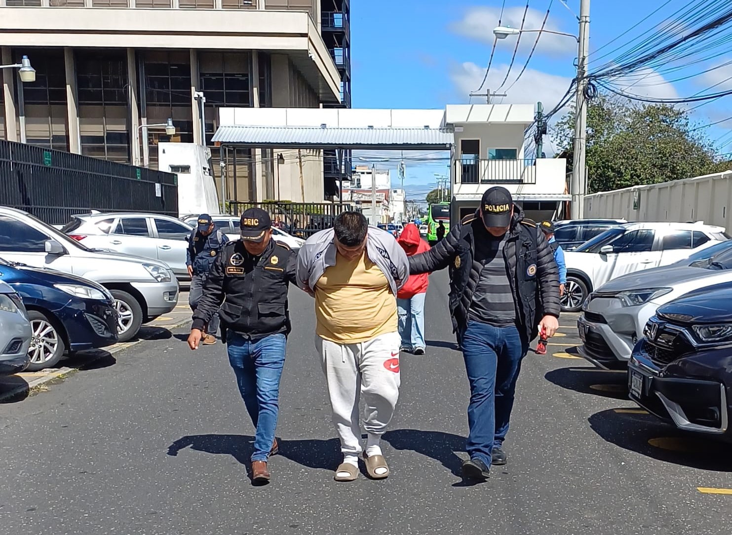 Agentes de la PNC conduce a uno de los capturados por usura en operativo transnacional.