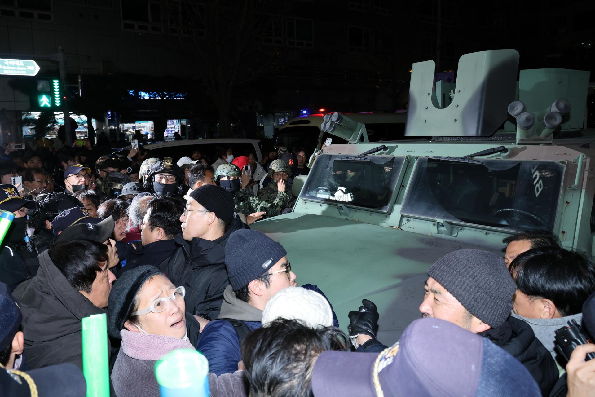 Ciudadanos surcoreanos rodeando un vehículo militar durante la ley marcial. / Foto: EFE.