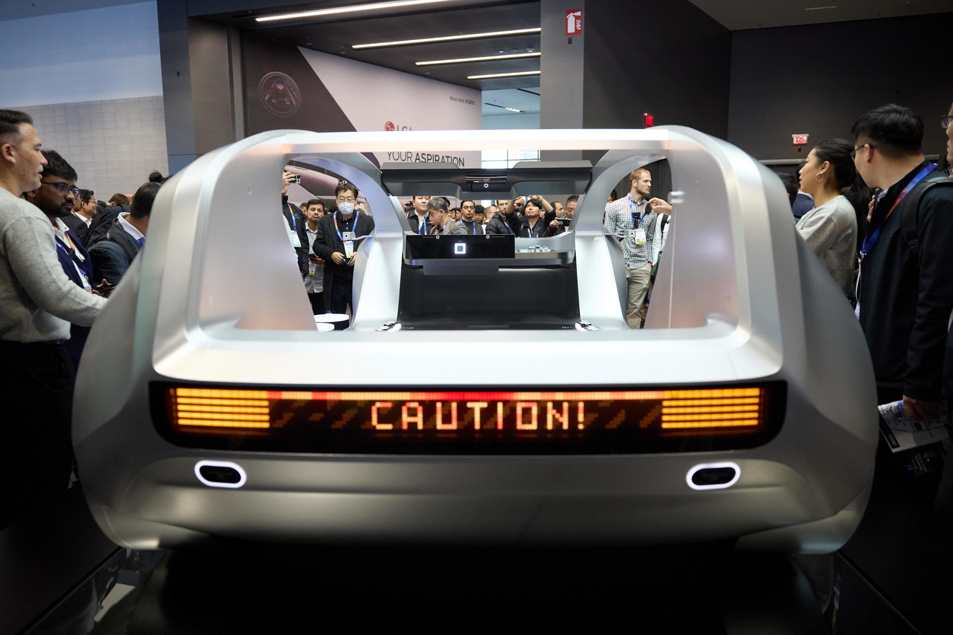 Asistentes la Feria Tecnológica de Consumo (CES) observan uno de los autos futuristas que se exhiben en esta gran convención en Las Vegas.