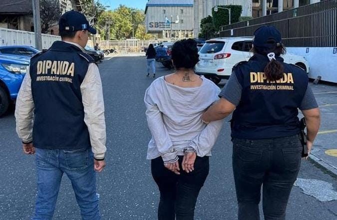 Agentes de la PNC trasladan a una mujer detinida en la zona 18, en acciones que forman parte de la lucha contra las extorsiones.