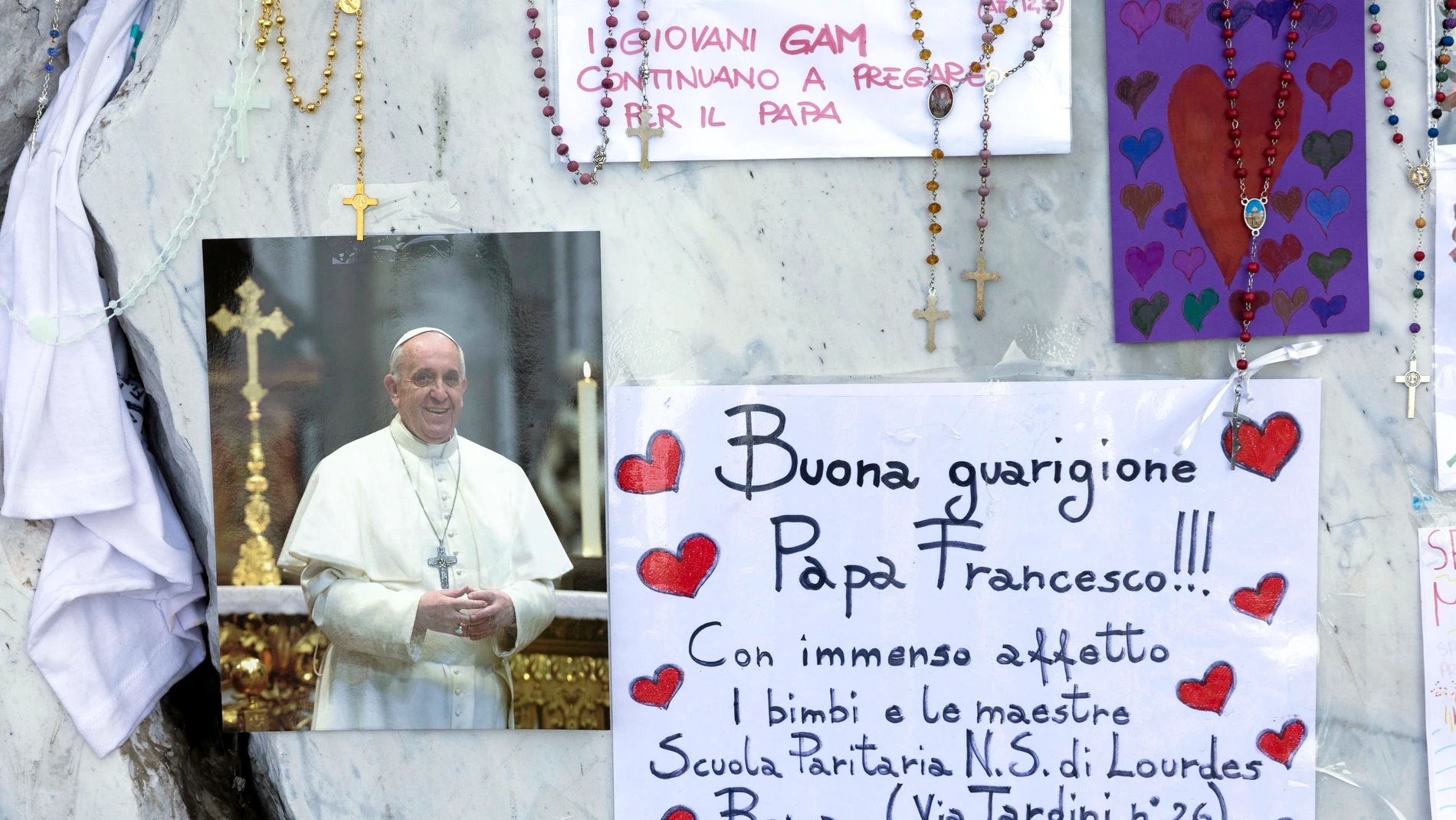 Junto a la estatua de Juan Pablo II frente al hospital Gemelli, donde se encuentra el papa Francisco, se han colocado mensajes con deseos por su pronta recuperación.