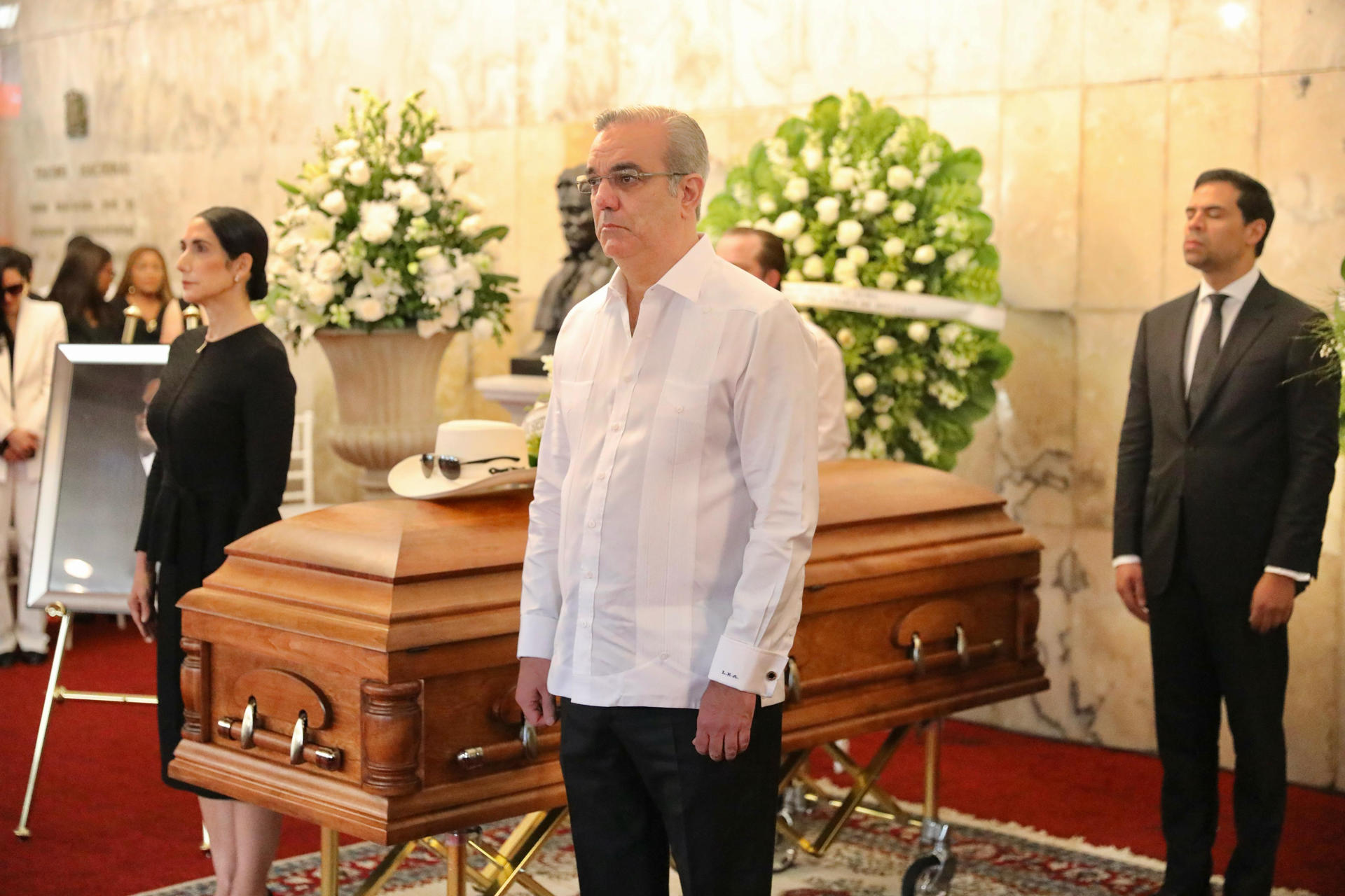 El presidente dominicano, Luis Abinader, hace guardia de honor ante el férretro del cantante Rubby Pérez, quien murió en la tragedia de la discoteca.