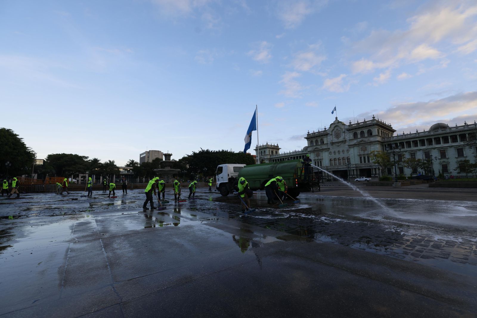Empleados municipales lavan la Plaza de la Constitución luego de que un grupo de maestros del STEG abandonara el lugar.