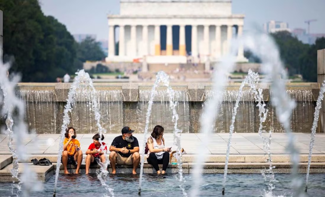 Una familia se refresca por el intenso calor durante una visita a monumentos en Washington.