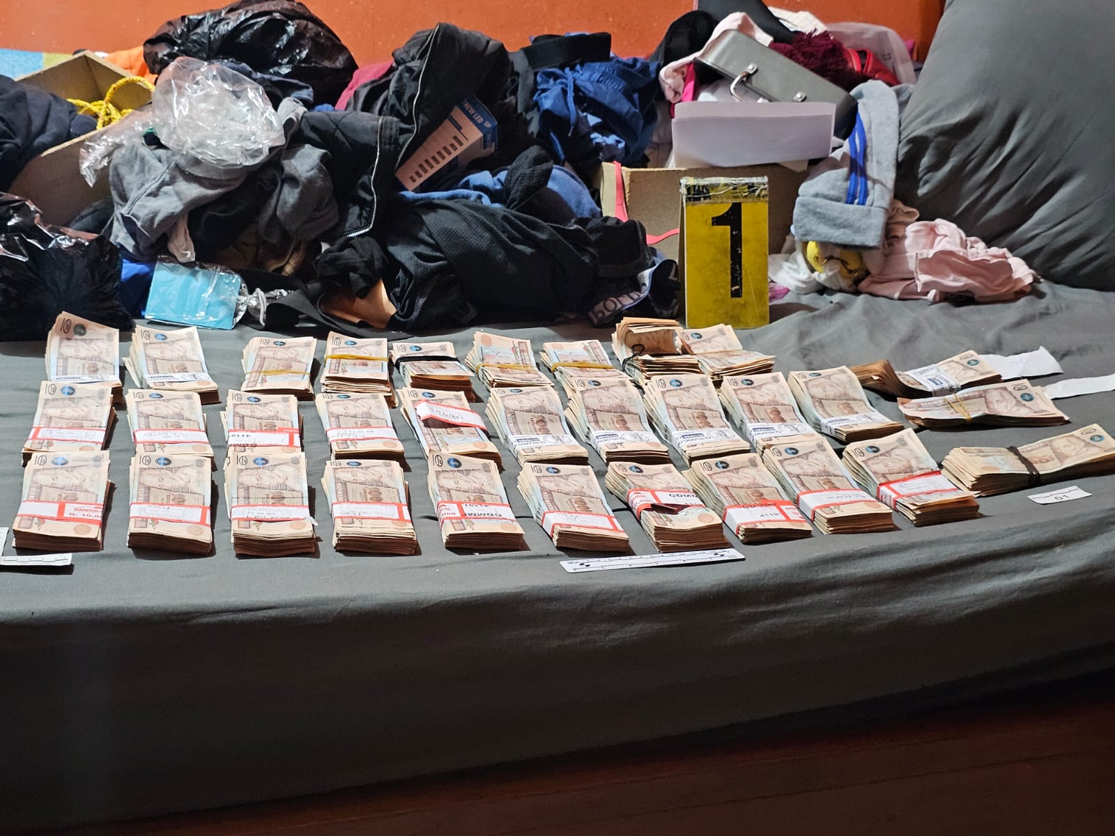 Dinero en efectivo y objetos que se decomisaron durante operativos contra asaltantes en varios puntos del departamento de Guatemala.