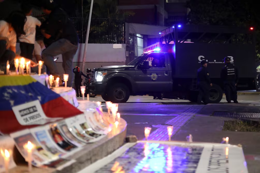 En un altar instalado en la afueras de una prisión venezolana se exhiben fotografías de presos políticos por quienes se pide su liberación.