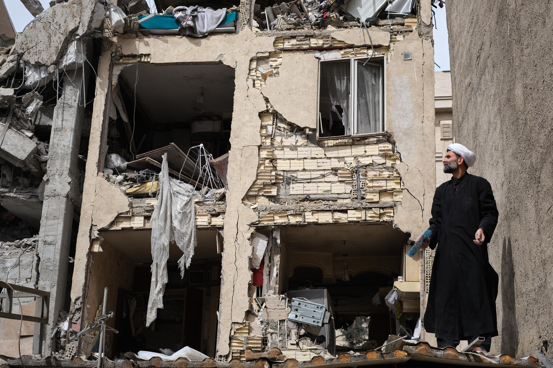 Un clérigo trabaja en la un edificio atacado en la calle Rajaei del sureño barrio de 13 de Aban, en la capital Teherán, Irán, que fue bombardeado en la madrugada por Estados Unidos e Israel donde trabajaban desescombrando. / Foto: EFE, Jaime León.