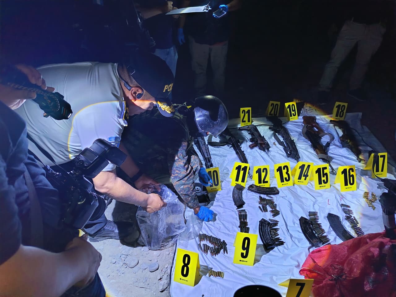 Agentes de la PNC ordenan las armas que se localizaron en un camino rural de San Marcos.