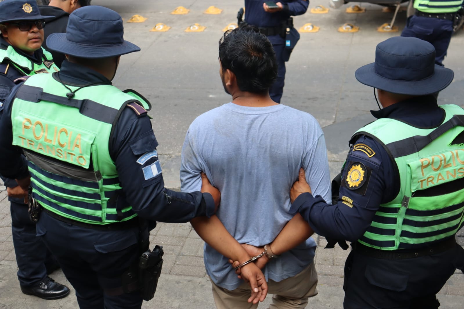Agentes de la PNC conducen a uno de los presuntos asaltantes capturados en la carretera a El Salvador.