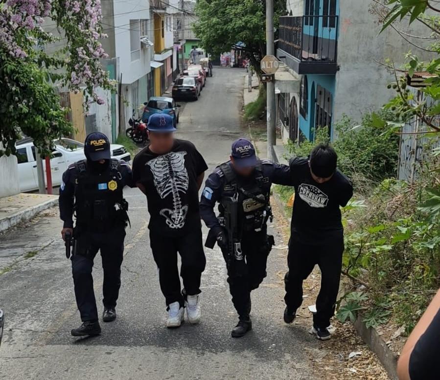 Agentes de la Comisaría 12 de la PNC conducen a los dos presuntos responsables de la muerte de concejal de Chinautla.